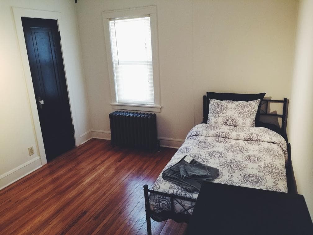 A private bedroom with hardwood floors and natural light
